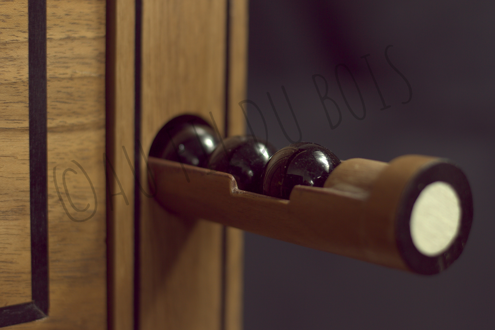 Vue de détail de la Table à jeux style Louis XVI sur le tiroir caché des billes du jeu Abalone